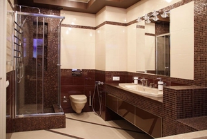 Стильный дизайн ванной с душевой кабиной в коричневых тонах.